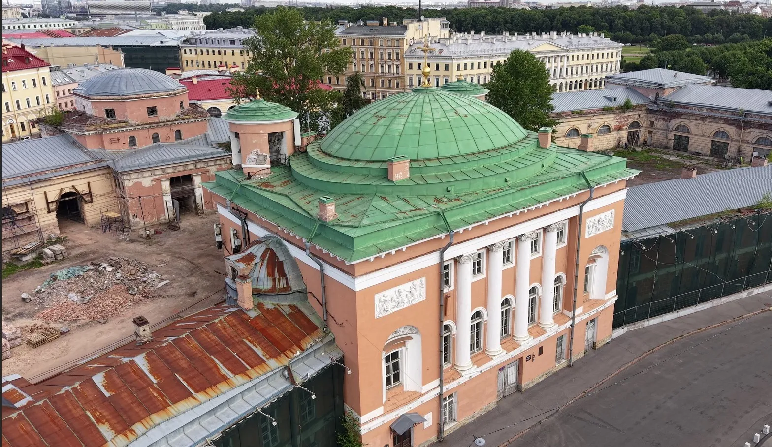 Съёмка с дрона: церковь с зелёным куполом и колоннами, слева двор в стройке